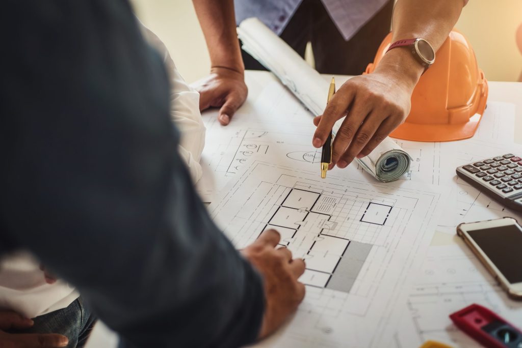 Aerial view of two team members discussing blueprints of a home project