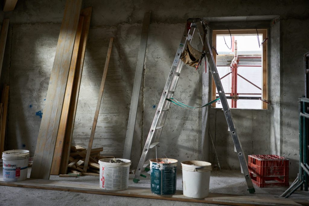 A ladder and paint buckets within an interior construction project